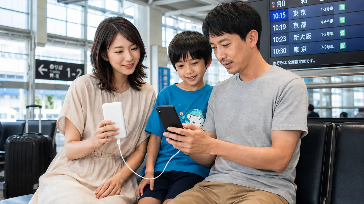 駅で家族旅行中にTORRASモバイルバッテリーでスマホを充電する様子