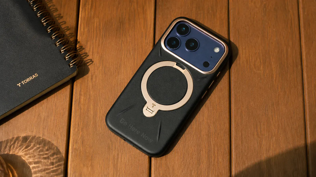 木製テーブルに置かれたTORRAS MagSafe対応レザー調スマホケース