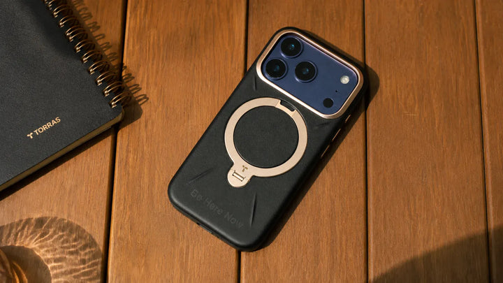 木製テーブルに置かれたTORRAS MagSafe対応レザー調スマホケース