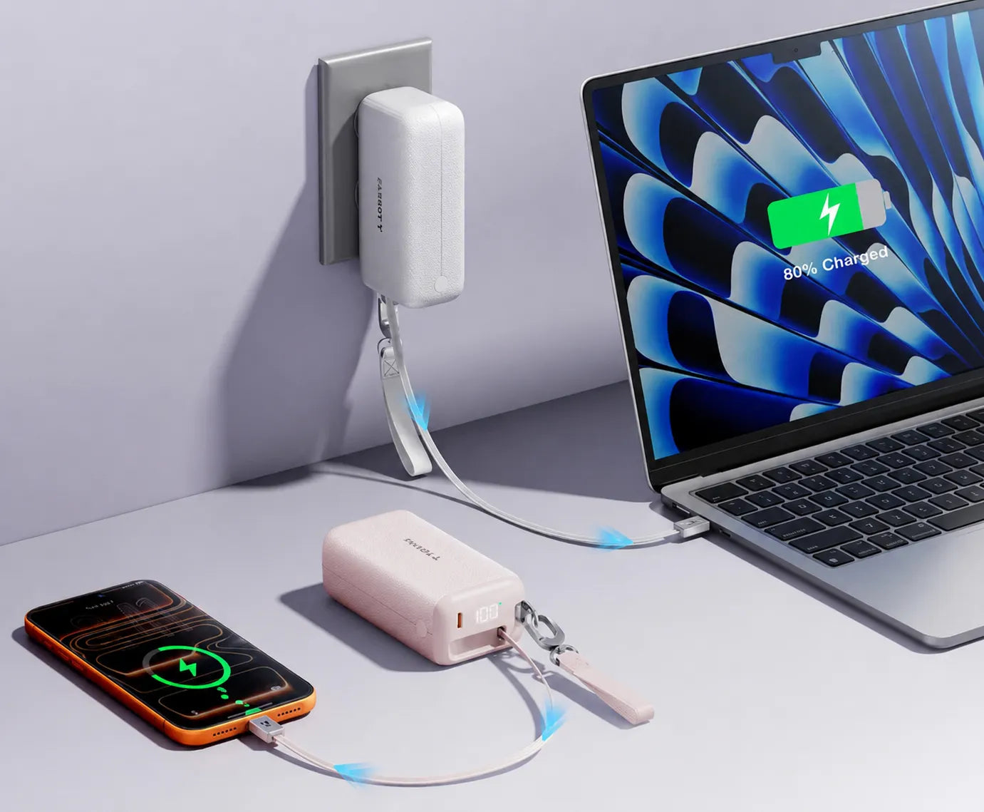 Torrasの白とピンクのポータブル電源がスマホとノートPCを同時に充電。壁コンセントから電源が伸び、ノートPC画面に「80% Charged」と表示。