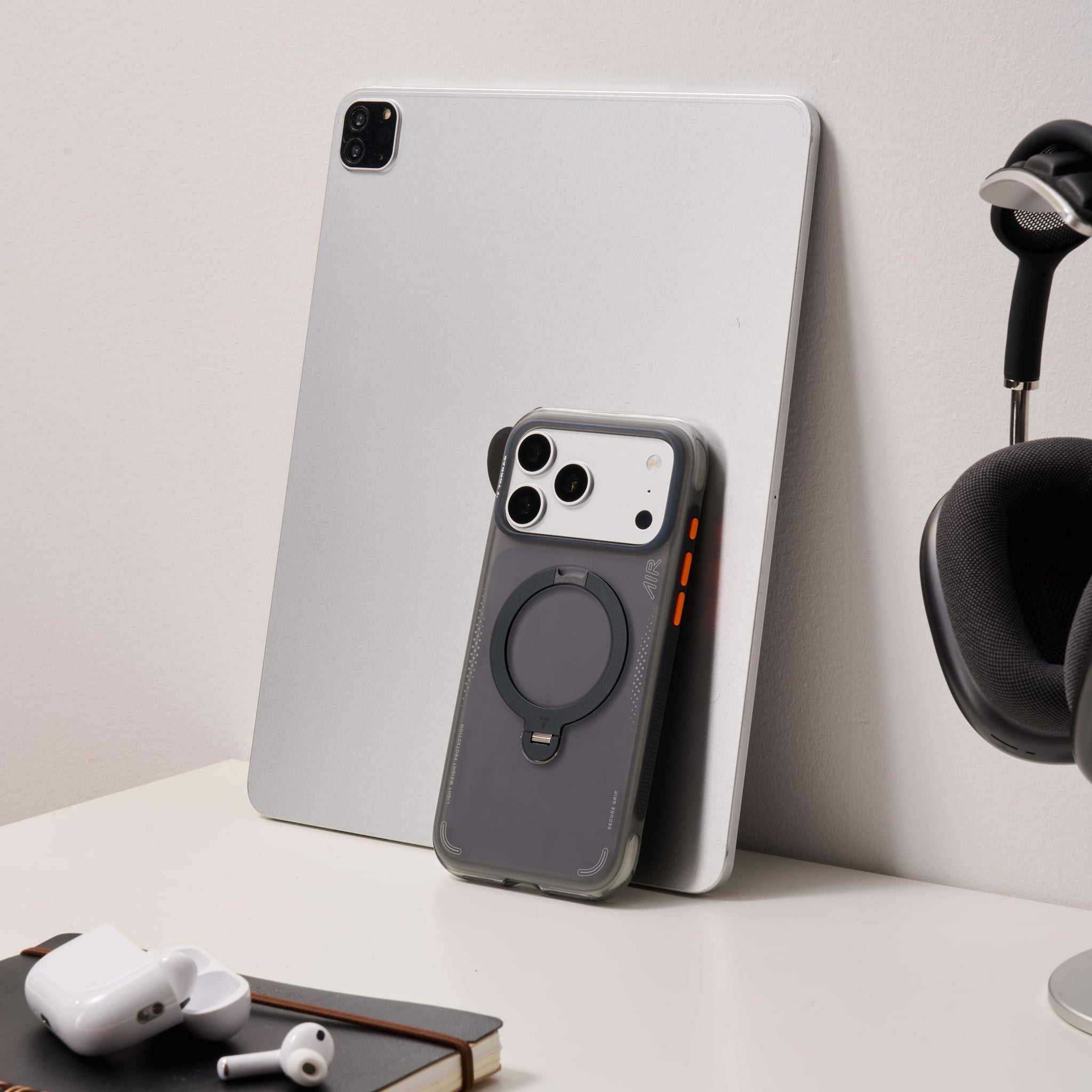 TORRAS Ostand Q3 Air ケース iPhone 18 Pro/Pro Max 対応、デスク上に置かれたシルバーiPhoneとブラックケースのスタンド使用例。