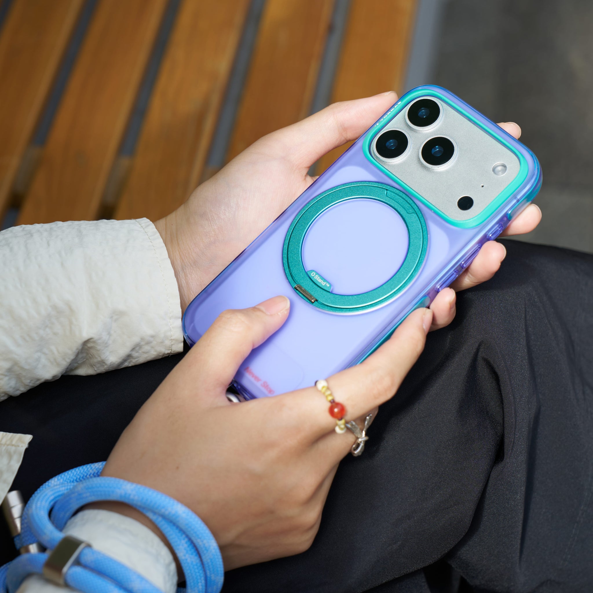 TORRAS Ostand O3 Hue ケース iPhone 18 Pro/Pro Max 対応、ブルーのクリアケースを持つ女性のライフスタイルシーン。