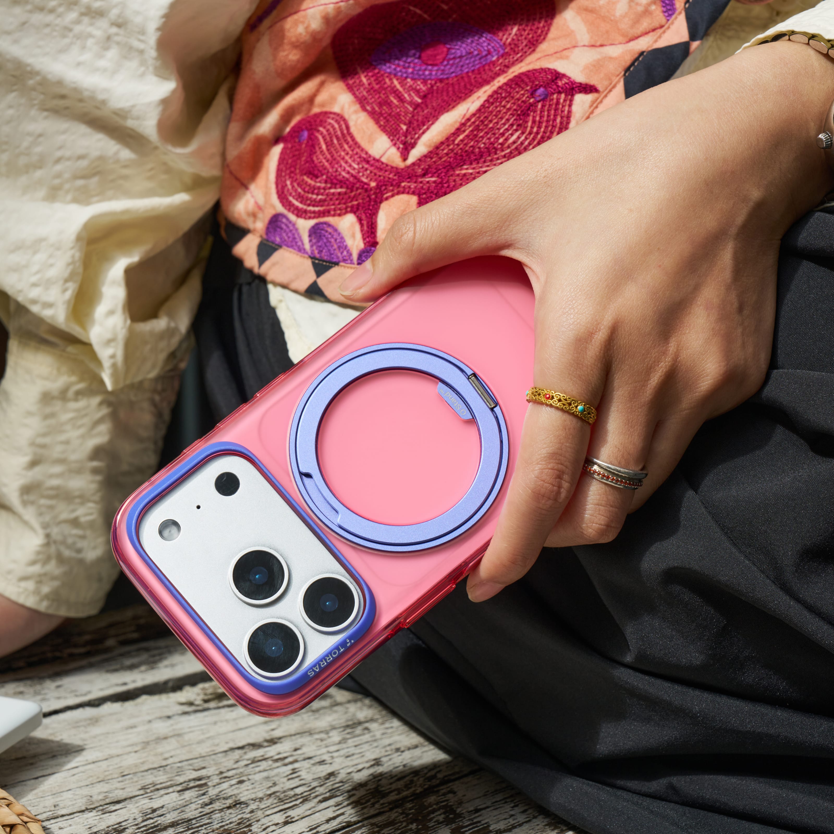 TORRAS Ostand O3 Hue ケース iPhone 18 Pro/Pro Max 対応、紫のクリアケースを紫のワンピース姿の女性が腰のポーチに入れて持つシーン。