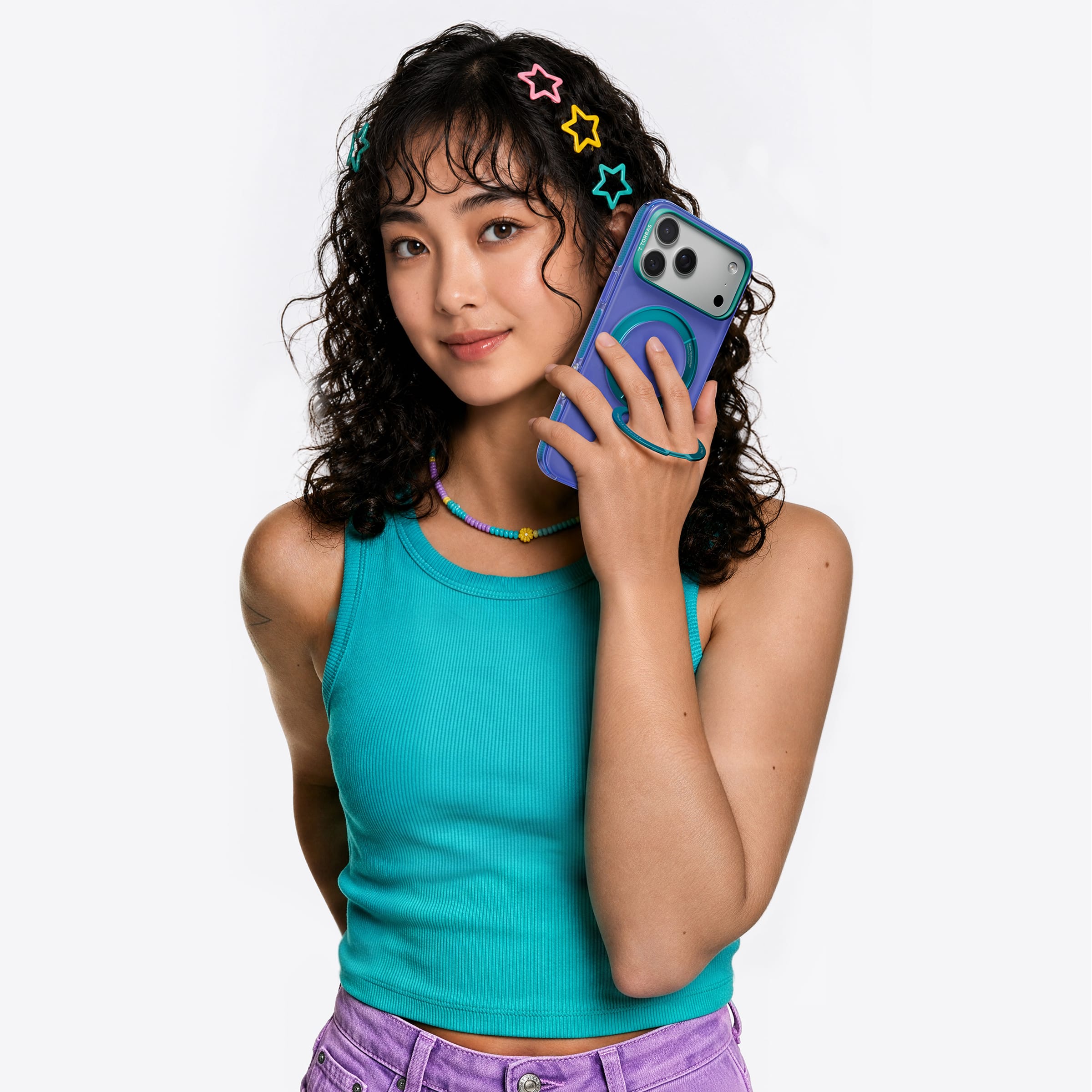 TORRAS Ostand O3 Hue ケース iPhone 18 Pro/Pro Max 対応、紫のクリアケースを顔の横にかざす巻き髪の女性ポートレート。