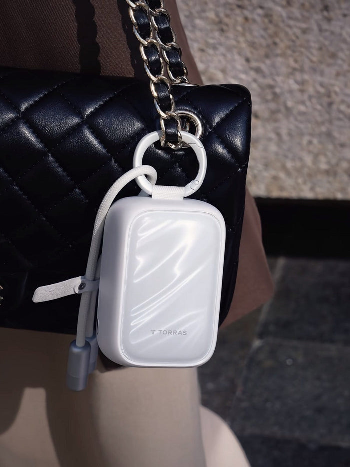 TORRASのFlexLine PearlGoホワイトポータブルパワーバンク、ハンドバッグに映えるおしゃれなアクセサリー。